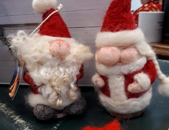 close up picture of 2 felted santa claus figures