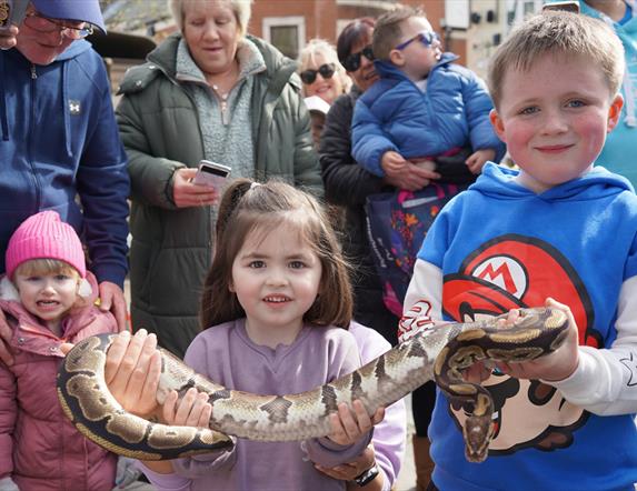 Children holding a snake
