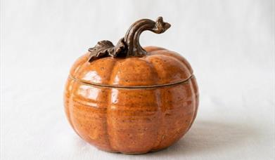 image of a ceramic pupmkin shaped bowl with lid on  a white background.