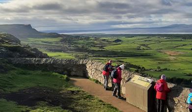 a group of walkers peer over a stone wall