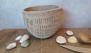 Small rounded bowl covered in an incised design.