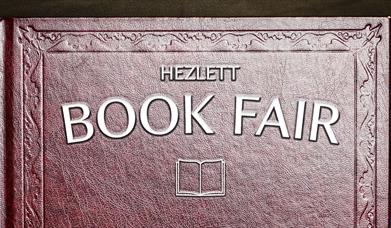 A poster for the National Trust's Hezlett Book Fair, embossed along the cover of an old leather bound book.