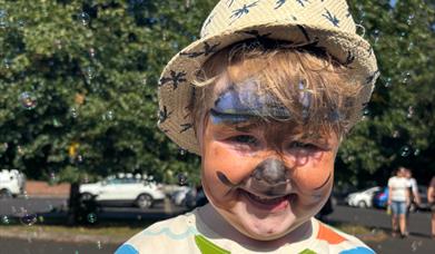 a young child with tiger face paint