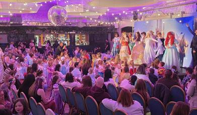 disney princesses on stage in front of a crowd