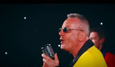 Singer in a yellow jacket with a vintage chrome microphone