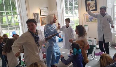 children and families with doctor and nurse characters moving busily in Flowerfied Arts Centre