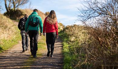 people walk on a rural hiking trail