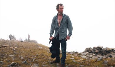 photograph of a man wandering in a deserted natural area.