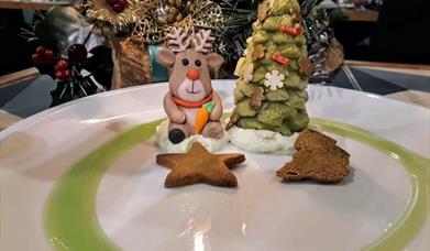a festive dessert which features gingerbread biscuits and desserts shaped as a reindeer and a christmas tree