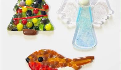 various fused glass decorations including a christmas tree, a robin and an angel