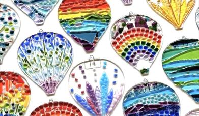 fused glass hot air balloons of a variety of shapes and sizes, with colourful patterns