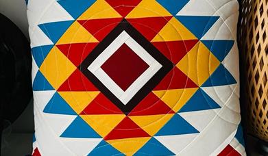quilted pillow with a colourful, geometric pattern