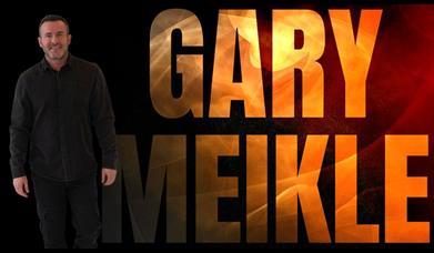 Image shows a man in a black suit with the words 'GARY MEIKLE' beside him