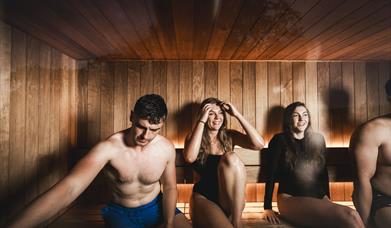 4 people relax in a sauna