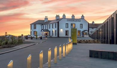 The Causeway Hotel bar accompanied by a beautiful pink and orange sunset in the background.