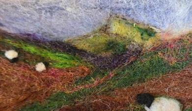 a depiction of a landscape with sheep made from felt 