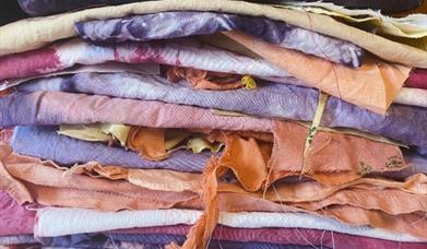 stacked textiles coloured a variety of natural colours