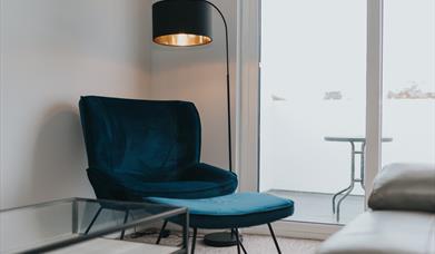 Lounge chair and lamp beside patio window
