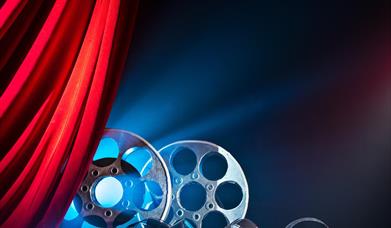 cinema film reels behind a red curtain