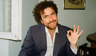 michael mcgovern posing with a drink in one hand