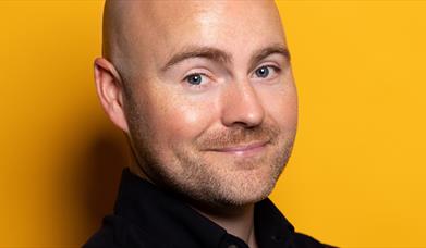 image of comedian Paddy Raff against a yellow background