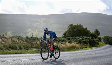 Man cycling with hills in the distance