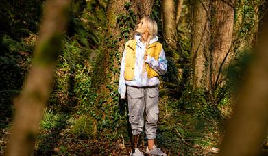 Girl standing pensively beside a tree as part of the Mussenden Unwind experience
