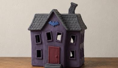 a haunted looking house made out of clay.