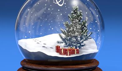 a festive snow globe with a tree and presents inside. 