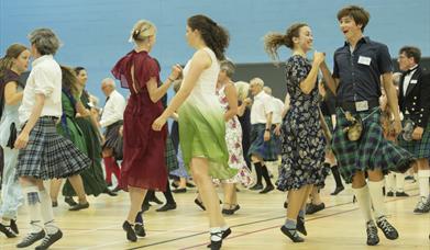 image of a group of peple dancing highland group dance. 
