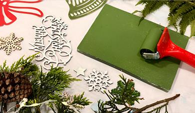 a number of materials for making and decorating christmas cards, including snowflakes, paint and mistletoes