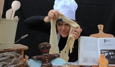 A woman in a chef's hat with pastry. 