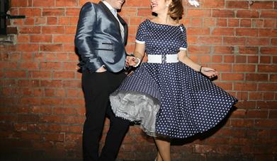 Photo of The Soda Popz in 50's style dress and suit.