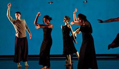 Dancers performing in front of a blue screen.