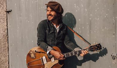 singer songwriter Brian Houston pictured with guitar