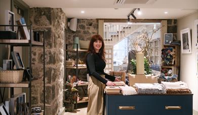 Person standing behind a shop counter in retail space at The Courthouse