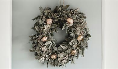 a wreath hanging on a wall, decorated with Easter ornaments