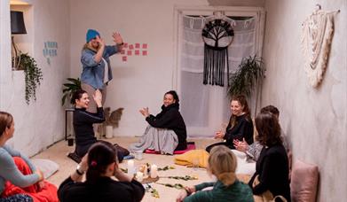 group of women in a room talking and joing their palms together