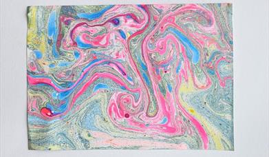 a print of many different bright colours all mixed and marbled together 