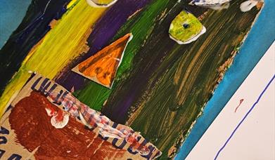 a multi-coloured mask being painted by a child