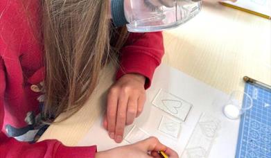 close up of a child working with fused glass 