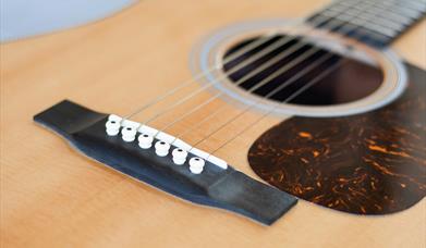 Close up photograph of an acoustic guitar