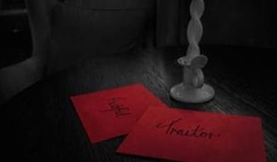 two red envelopes on a table, one reads "faithful" and the other "traitor"