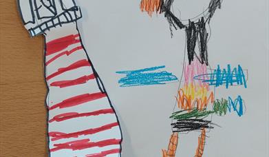 A child's drawing of a colourful puffin accompanied by a cut-out lighthouse. 