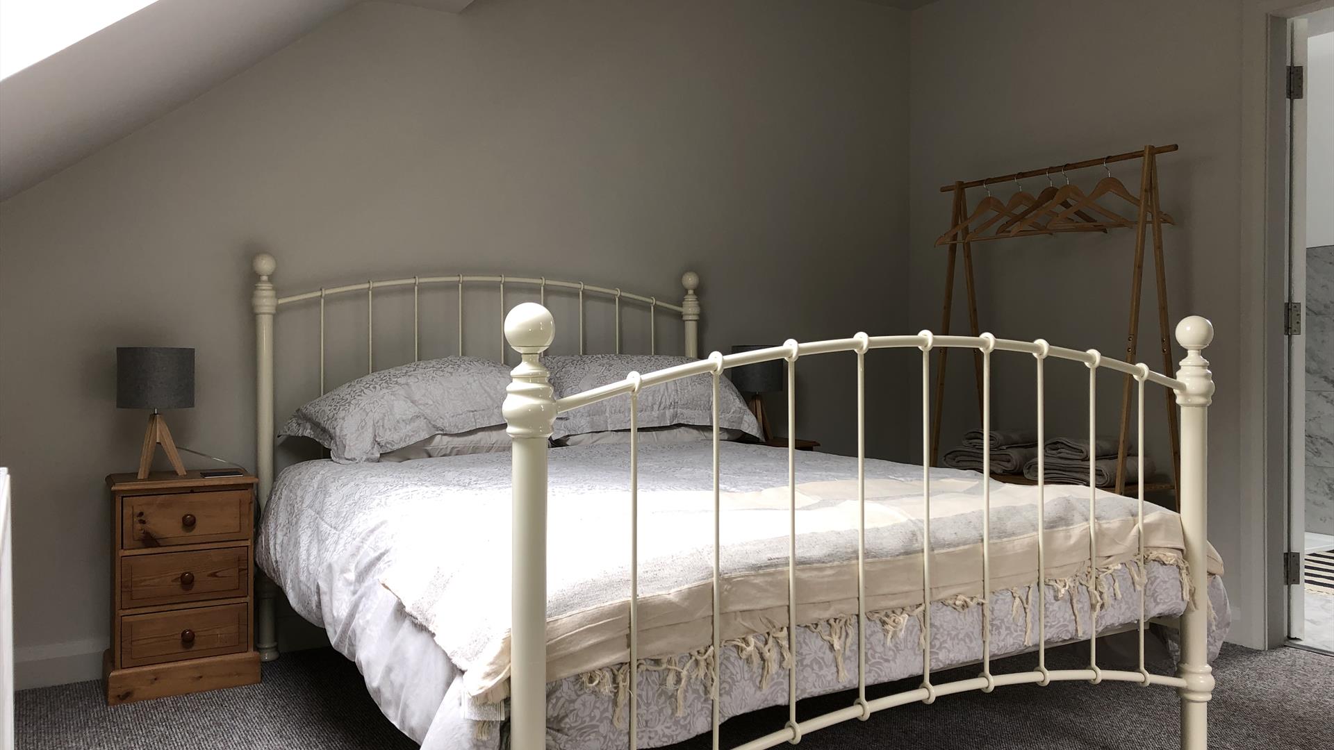 Bed, bedside cabinets, lamps and wardrobe in bedroom at The Heagry