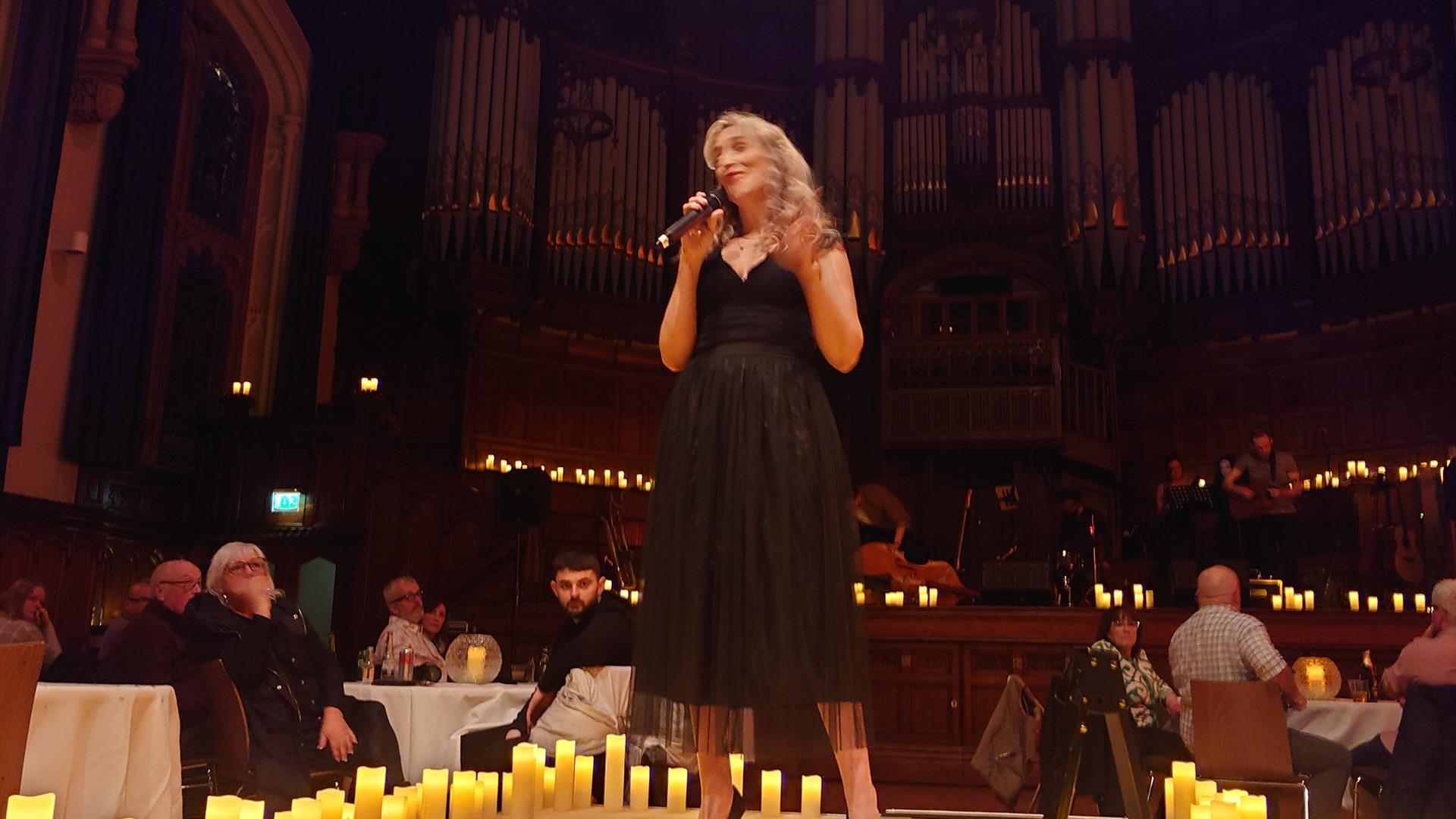 singer on stage surrounded by candles