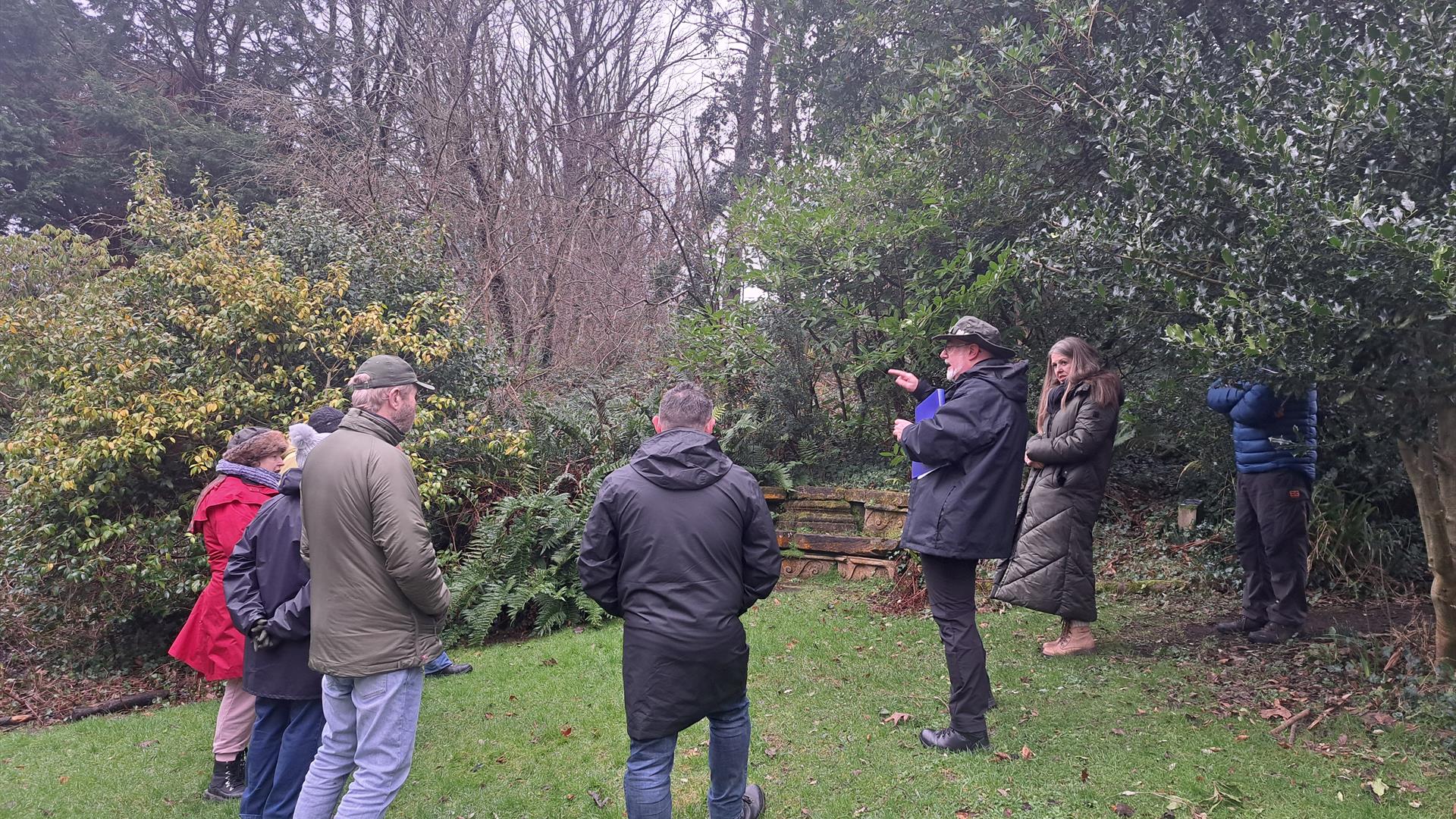Bob Picken guiding a group dressed in outdoor clothing and hearing stories of the Earl Bishop