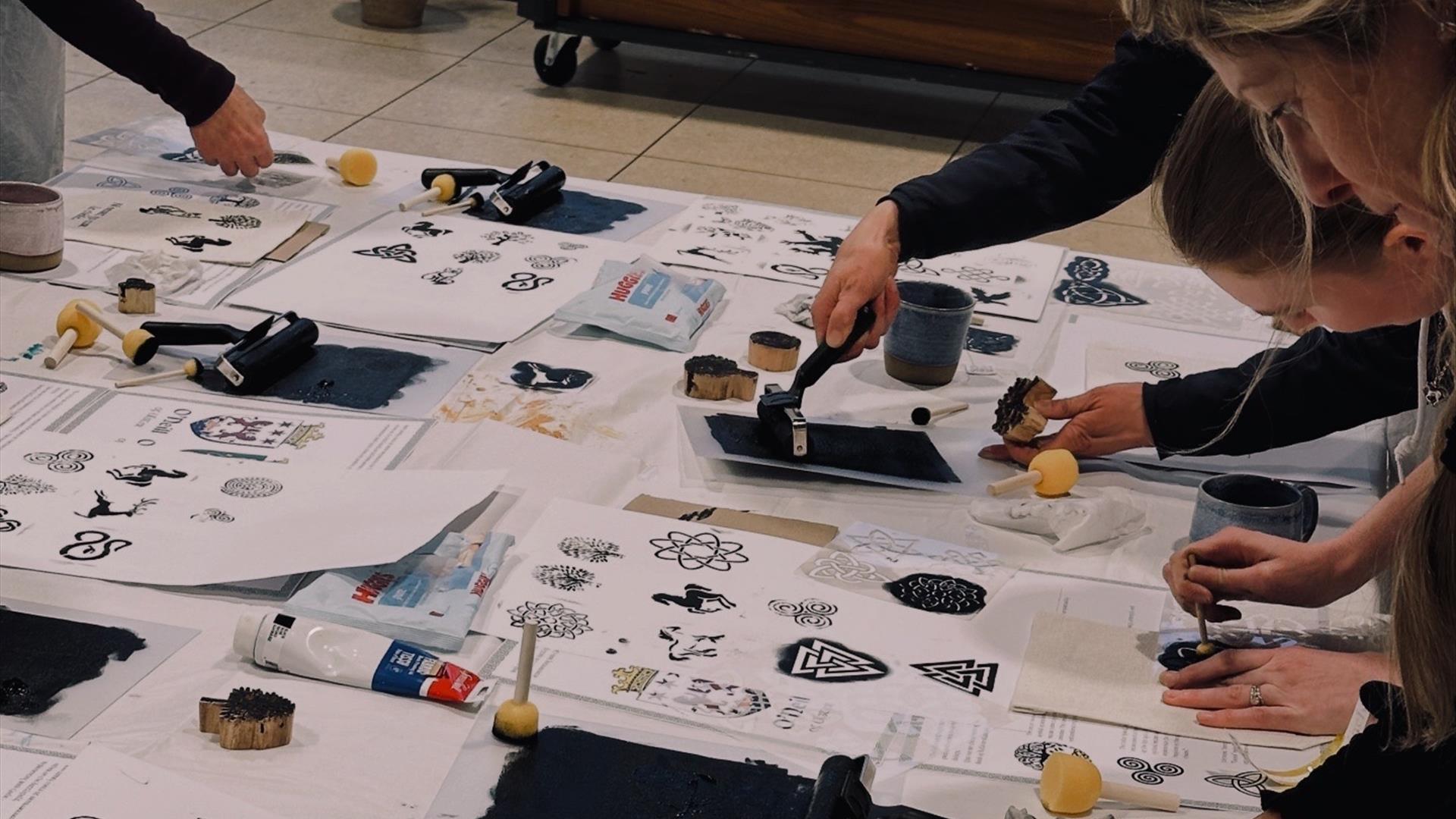 a number of people all working on irish themed prints