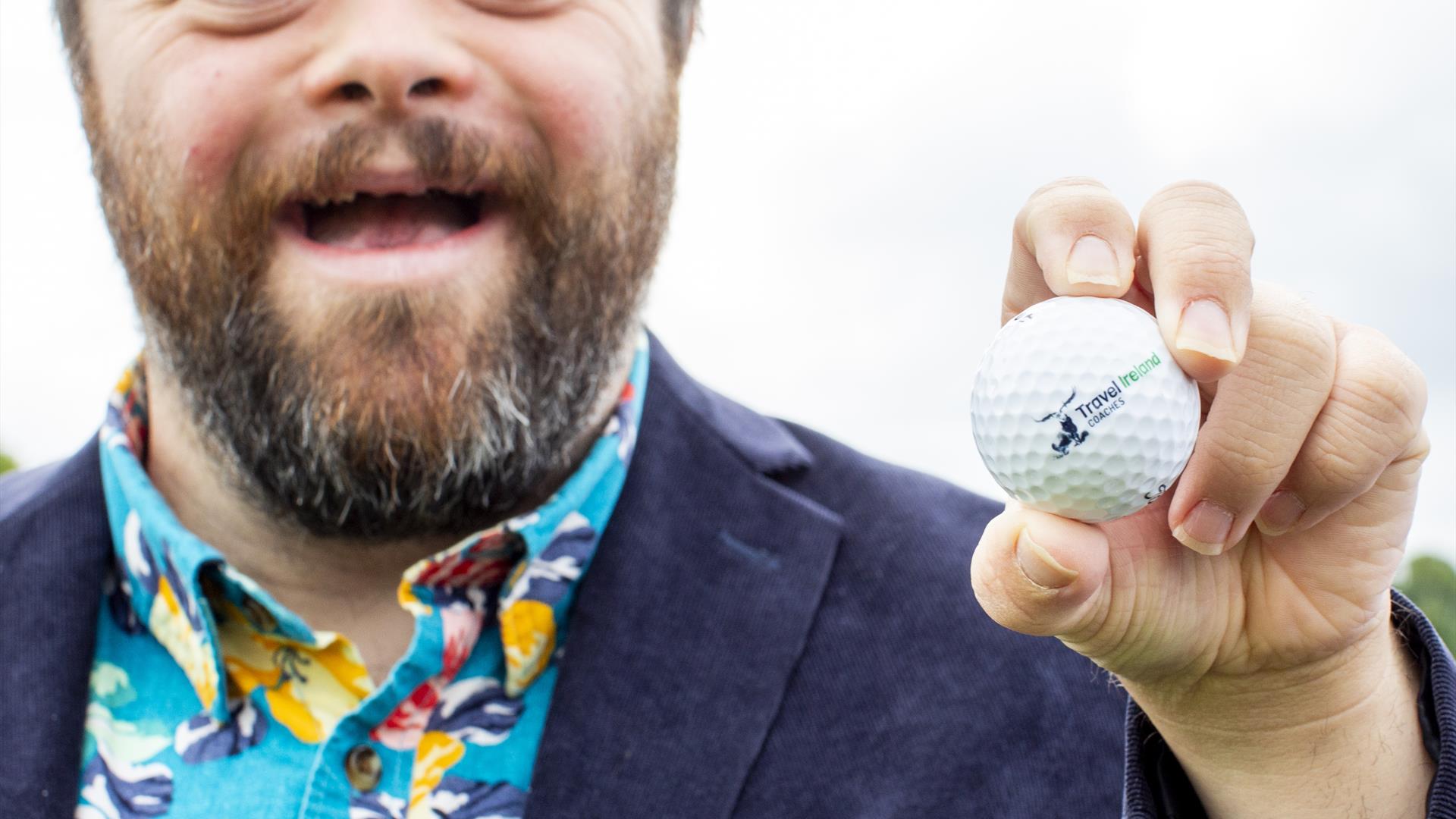 James Martin MBE, holding a golf ball and smiling for the camera.