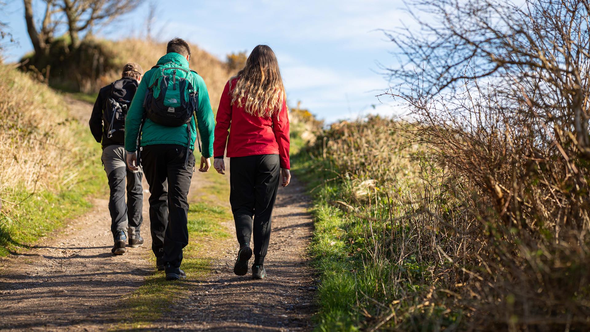 people walk on a rural hiking trail